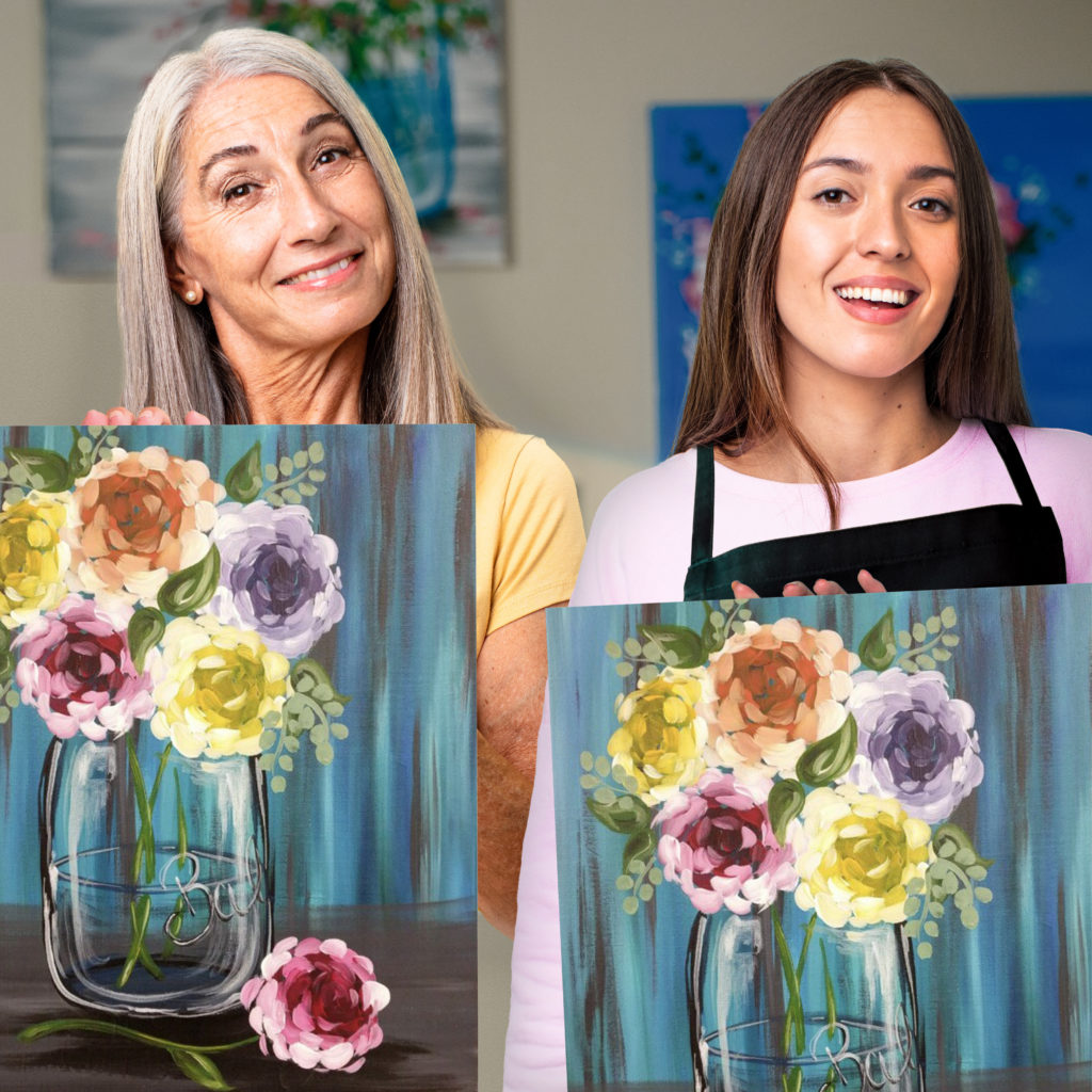 mom and daughter holding painting of flowers